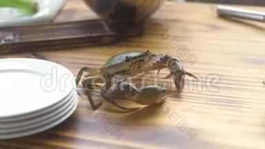 在厨房海鲜餐厅的木桌上奔跑的活蟹.. 海蟹在海鲜餐厅烹饪前。 新鲜